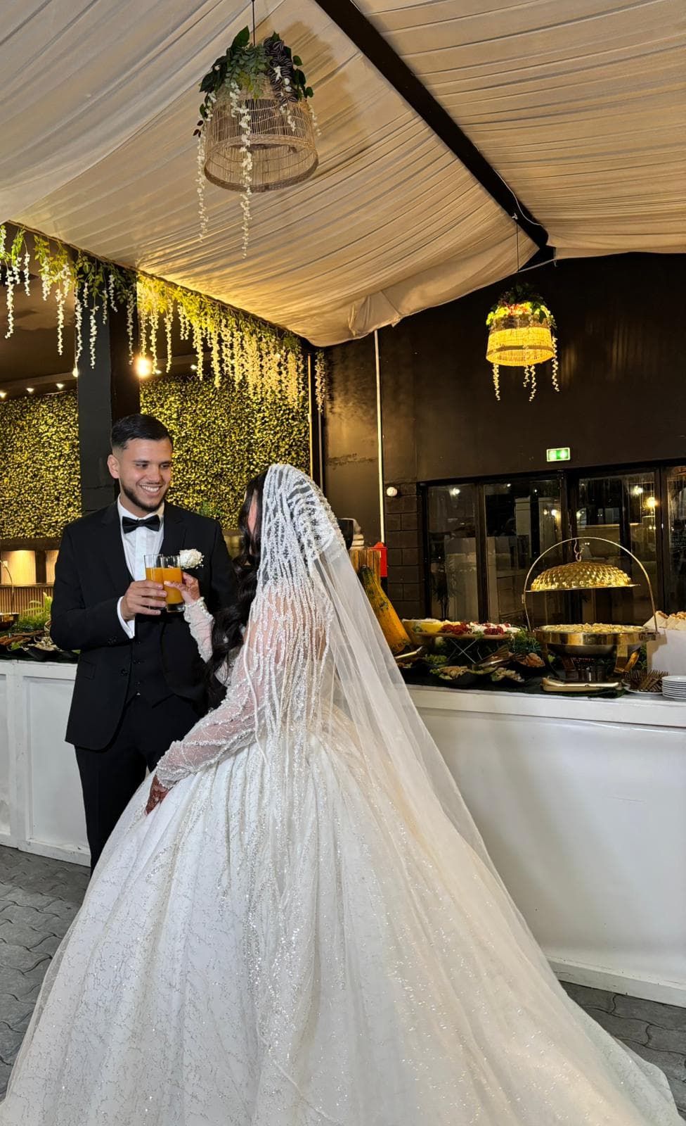 Mariée et marié levant un toast près du buffet